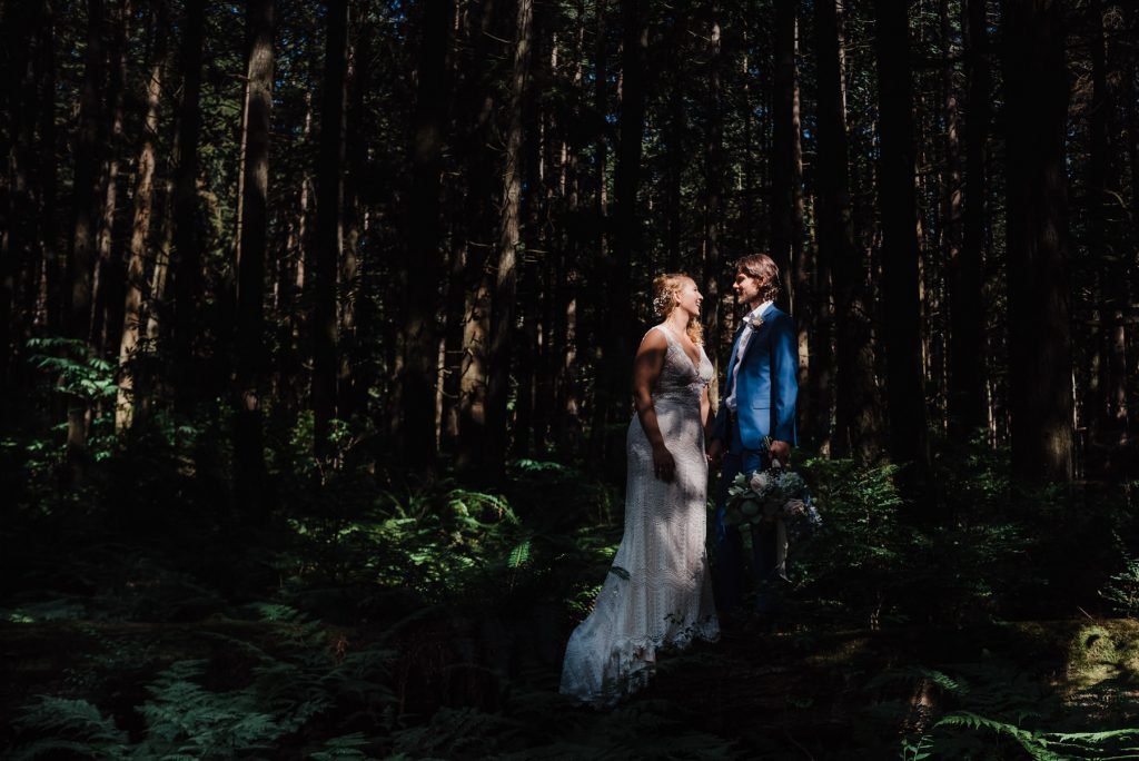 Moody photo of bride and groom in the woods during intimate elopement 