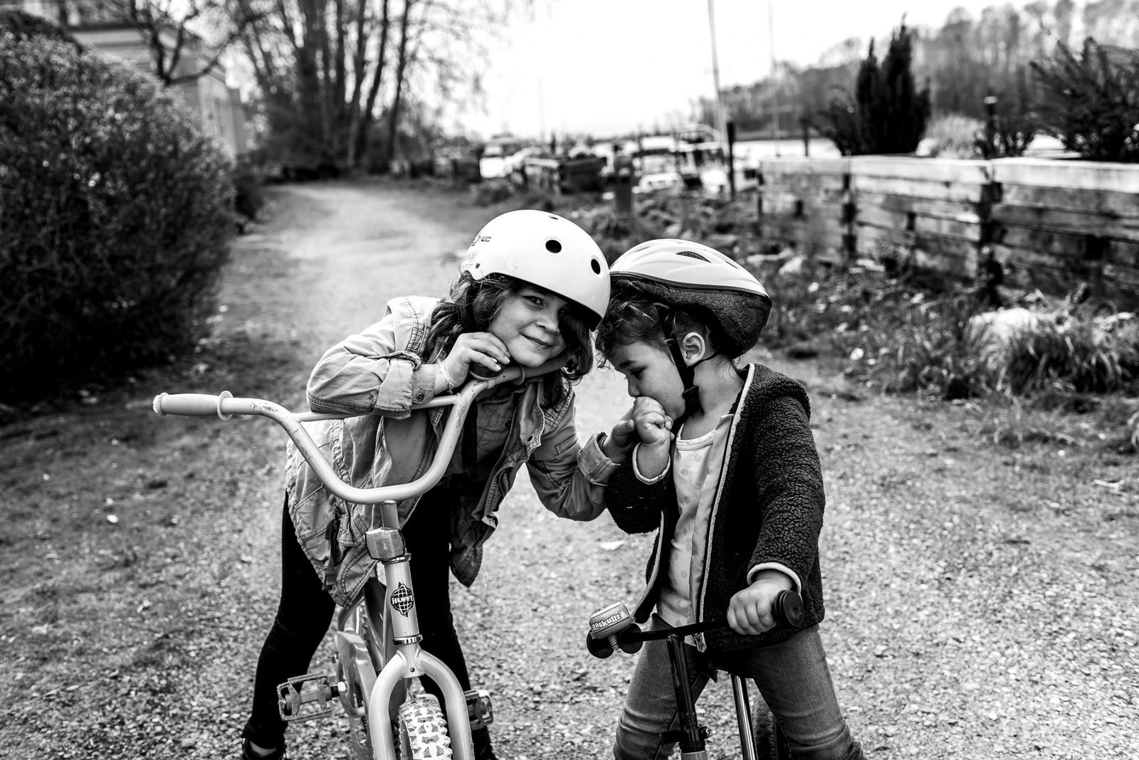 Sisters ride their bikes during lifestyle family photos in Ladner, BC.